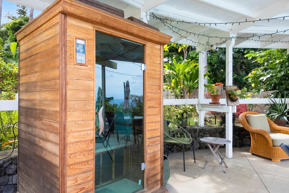 Outdoor sauna surrounded by greenery and seating areas.