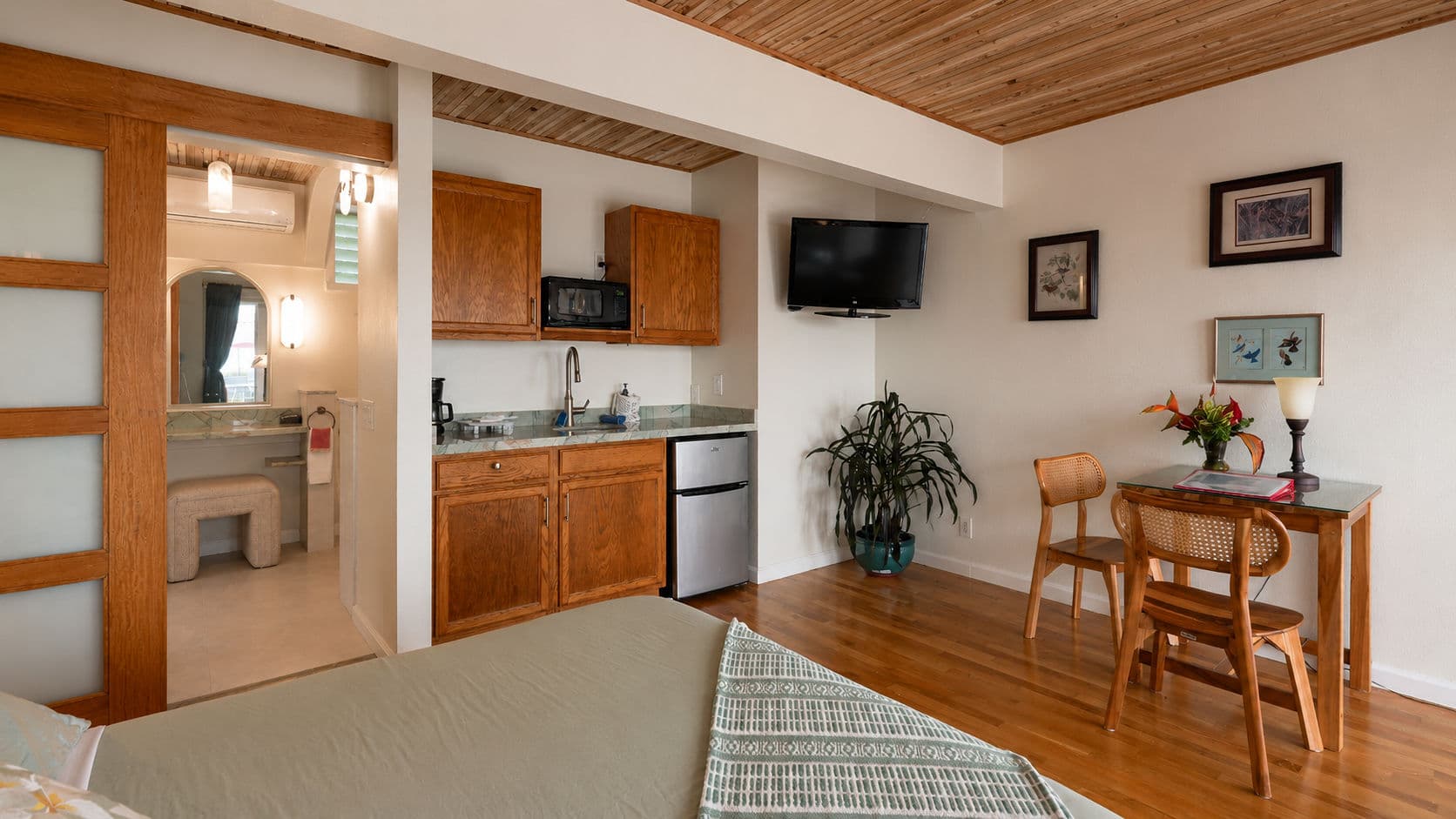 Cozy room featuring a kitchenette, dining area, and a bathroom with modern accents.